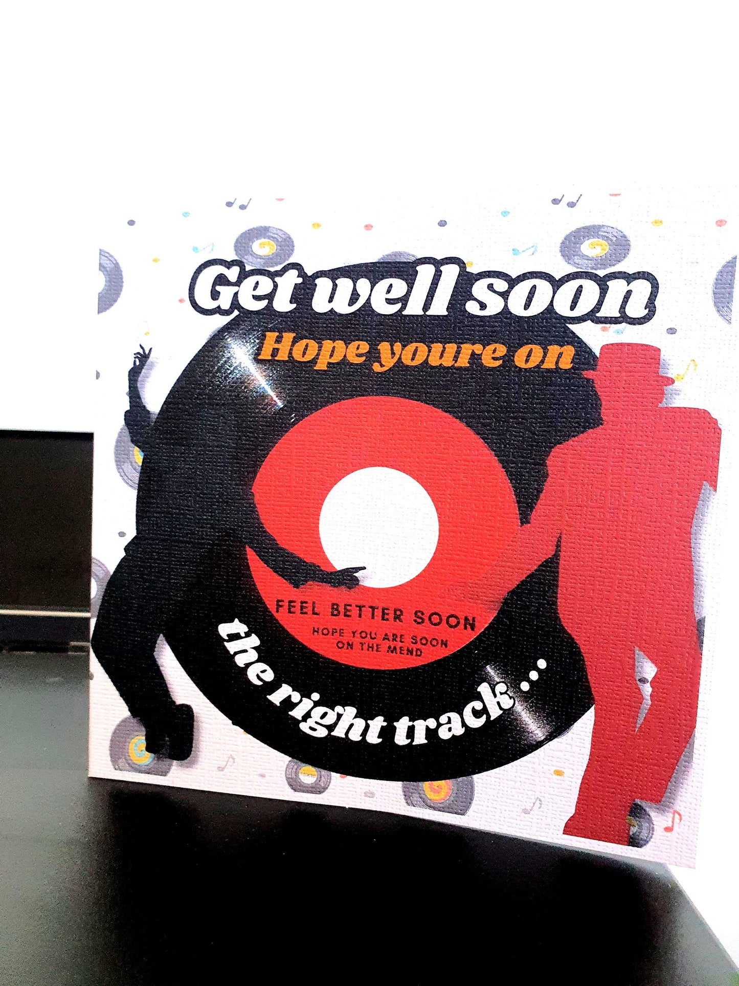 Get well soon card with vinyl record design and dancing figures on a white background.