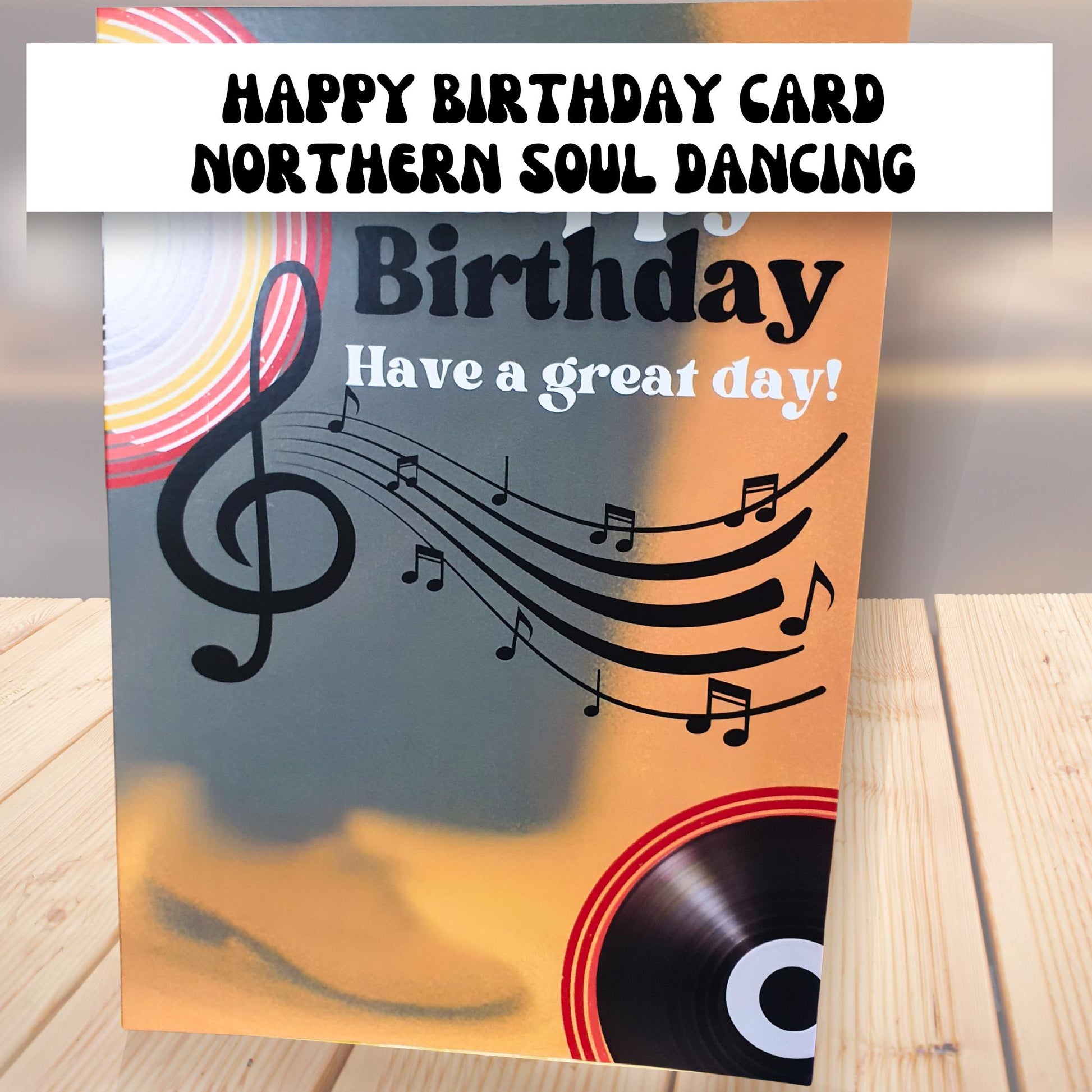 Happy Birthday card with mens trousers and shoes and music notes and record design on a wooden surface