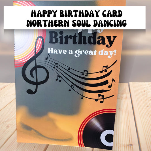 Happy Birthday card with mens trousers and shoes and music notes and record design on a wooden surface