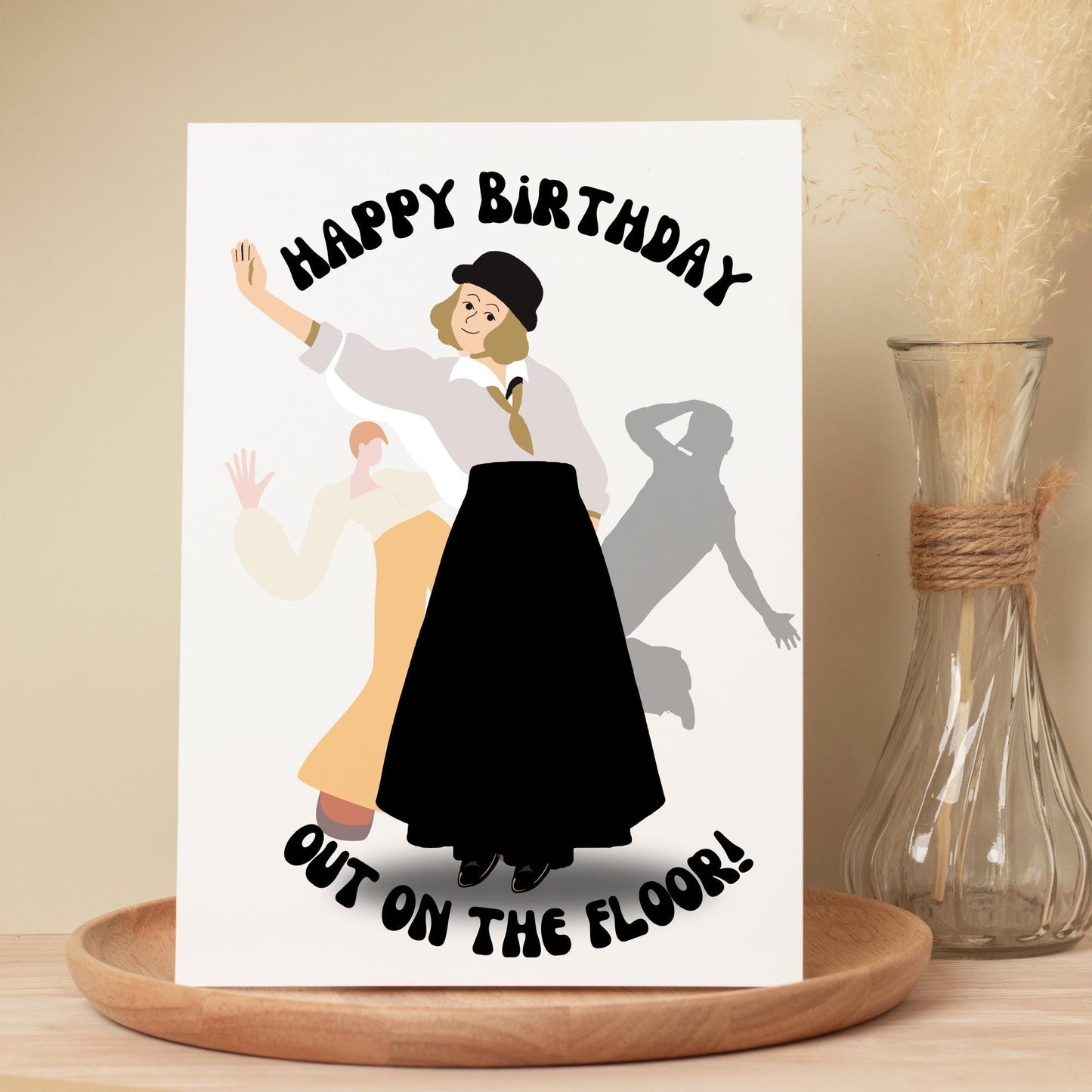Birthday card with illustration of a woman dancing and text 'Happy Birthday Out on the Floor' on a white background.