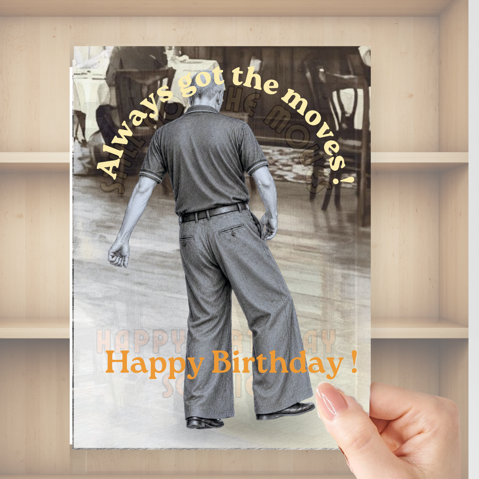 a card in front of a bookshelf being held my a hand depicting the monochrome image of northern soul man middle aged in polo shirt and wide leg trousers dancing with text stating always got the moves