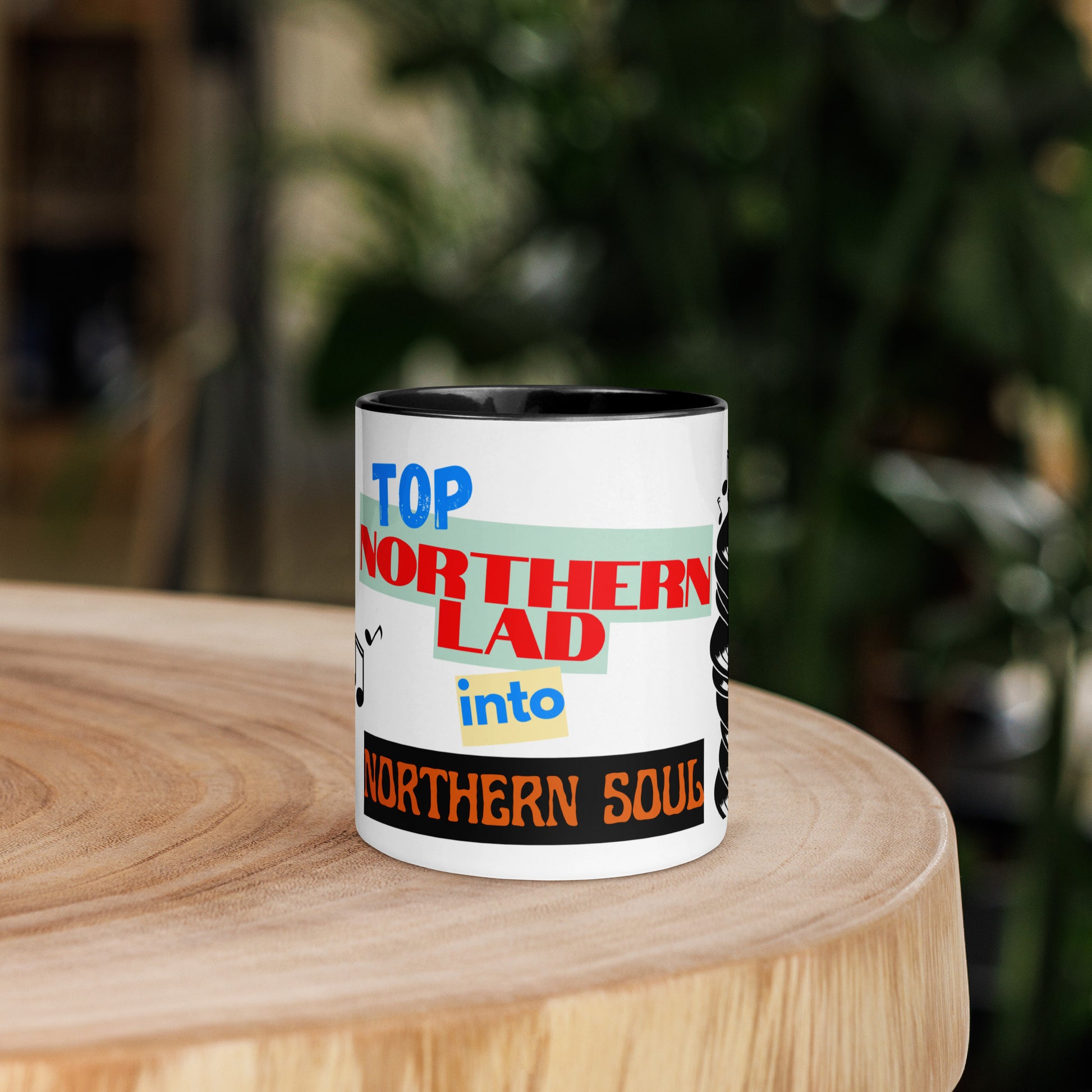 Mug with colorful text design stating northern lad into northern soul on a wooden surface