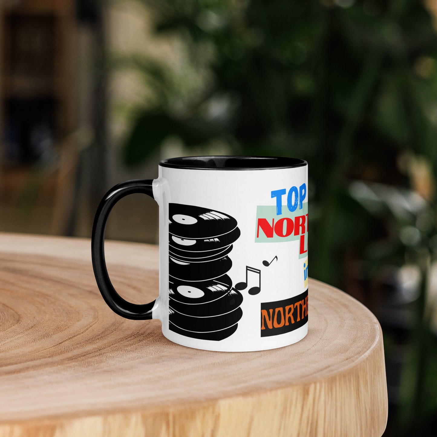 Mug with vinyl record design and 'Top northern lad ' text on a wooden surface