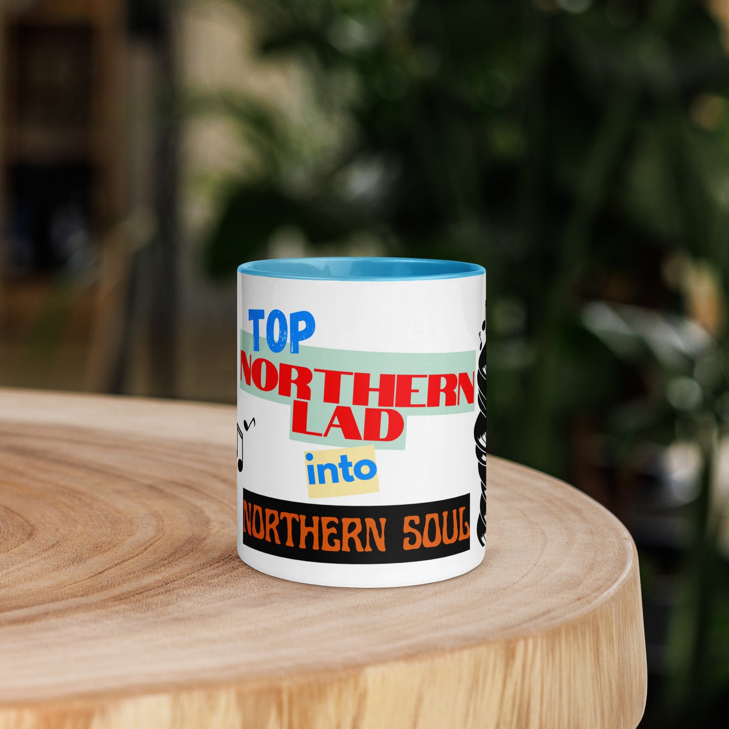 Mug with colorful text design stating northern lad into northern soul on a wooden surface