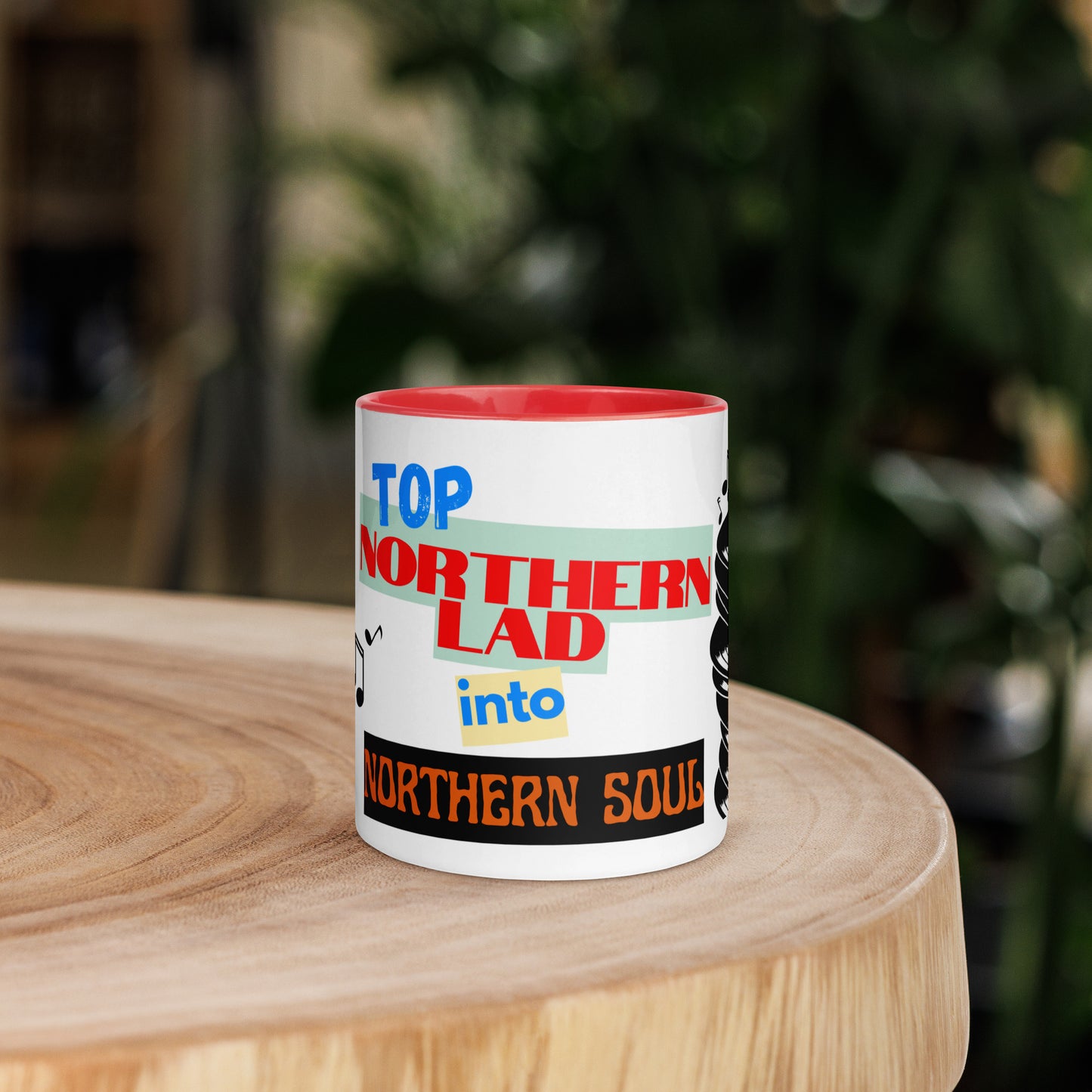 Mug with colorful text design stating northern lad into northern soul on a wooden surface