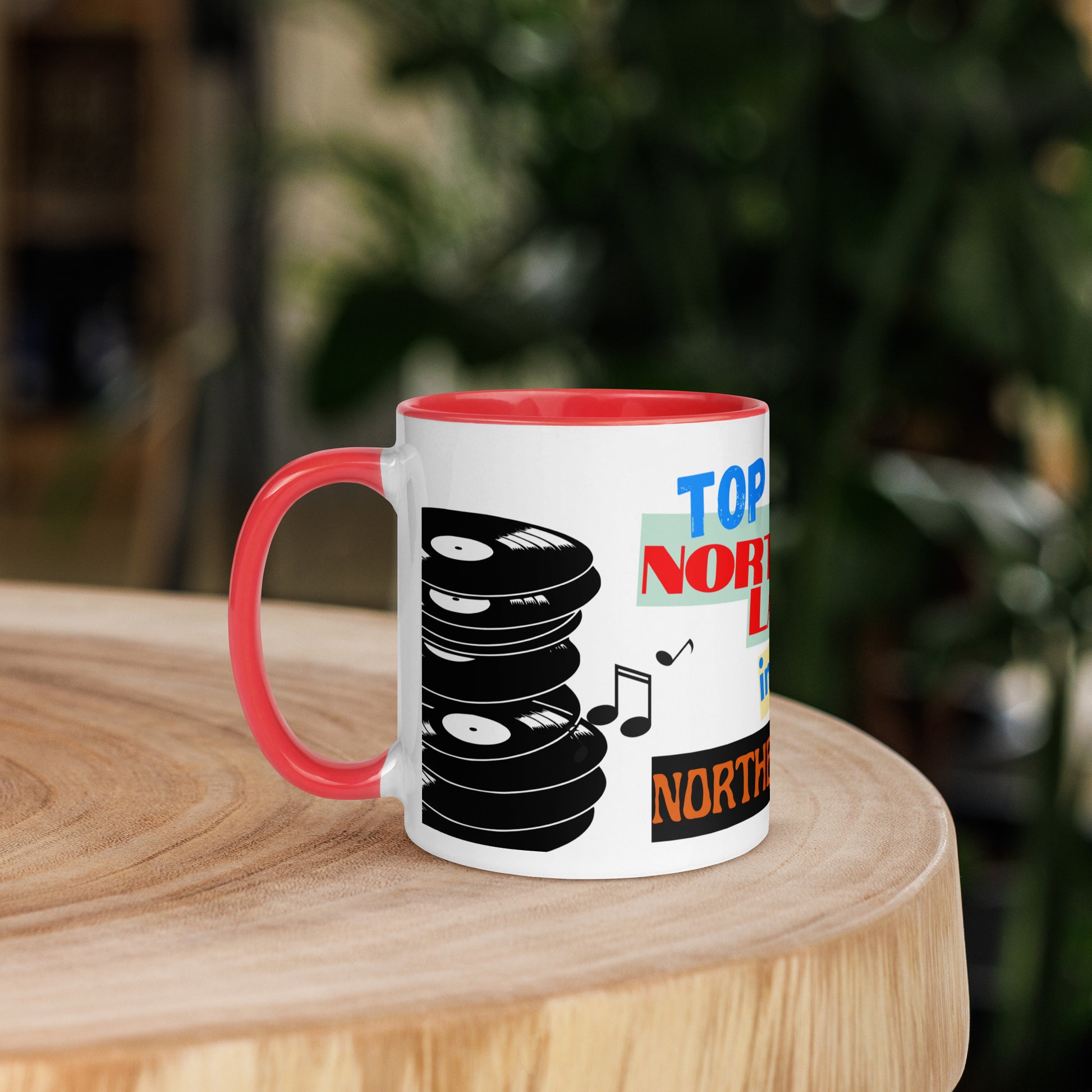 Mug with vinyl record design and 'Top northern lad ' text on a wooden surface